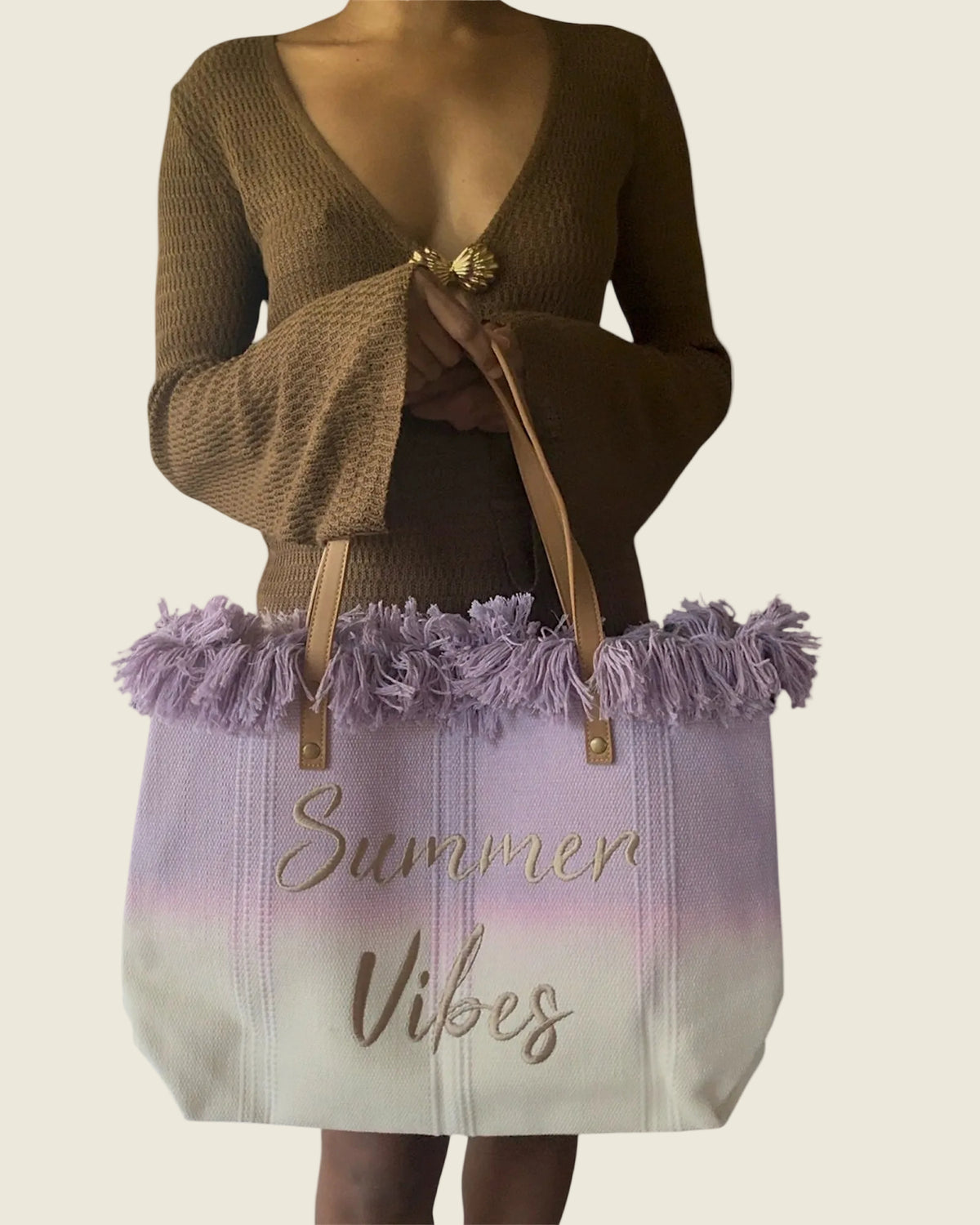 Sac cabas Summer Vibes lilas et écru à franges, porté devant une robe marron