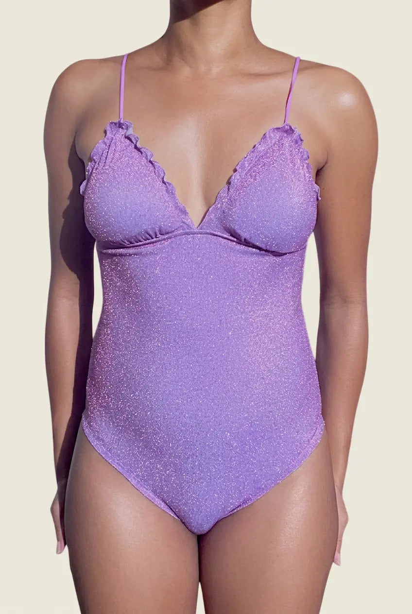 Maillot de bain une pièce lilas scintillant vu de face, avec décolleté en V et bords froncés