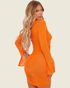 Robe courte orange portée de trois quarts dos, avec coupe ajustée, fronces et poignets évasés.