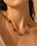 Collier chaîne dorée avec perles en œil de tigre porté par une femme, style naturel beach-luxe