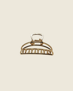 Pince crabe dorée ajourée à ressorts métalliques, design demi-lune avec découpes rectangulaires, finition brillante